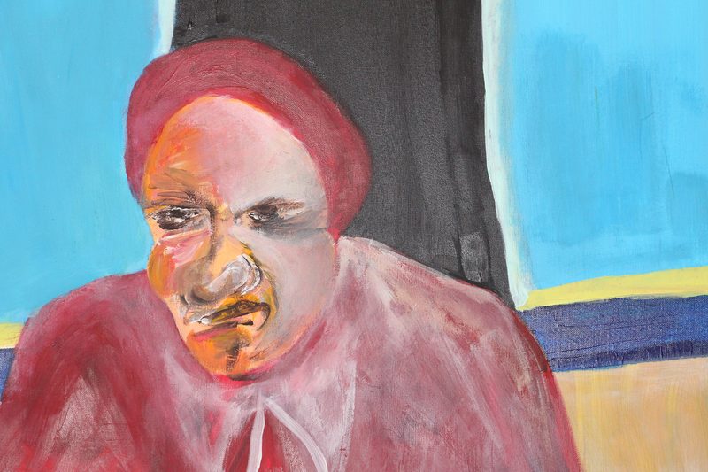 The smaller head of 7 fam board game, scowling under a dark red cap.
